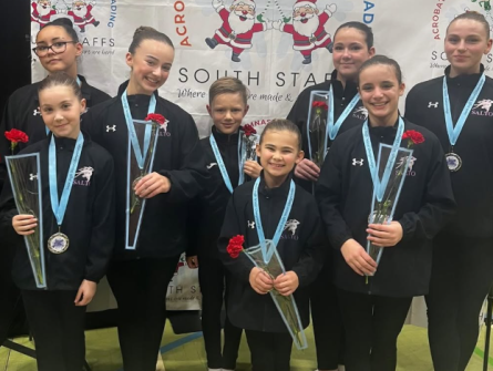 Eight Acrobatic Gymnasts each holding a red rose 