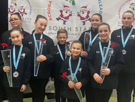 Eight Acrobatic Gymnasts each holding a red rose 