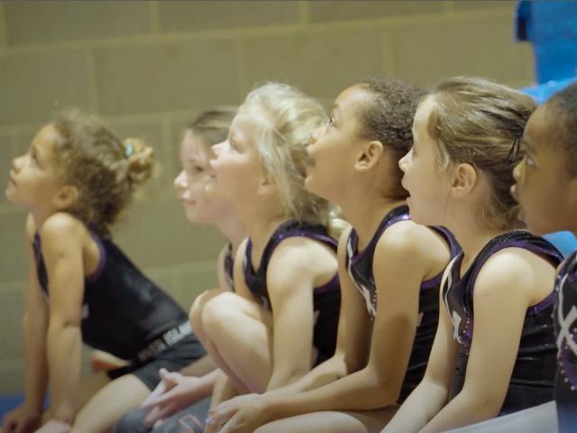 Young girls sitting on mat looking