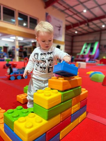 little boy building with large soft lego blocks